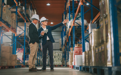 asian chinese management having discussion at warehouse with white hardhat using digital tablet